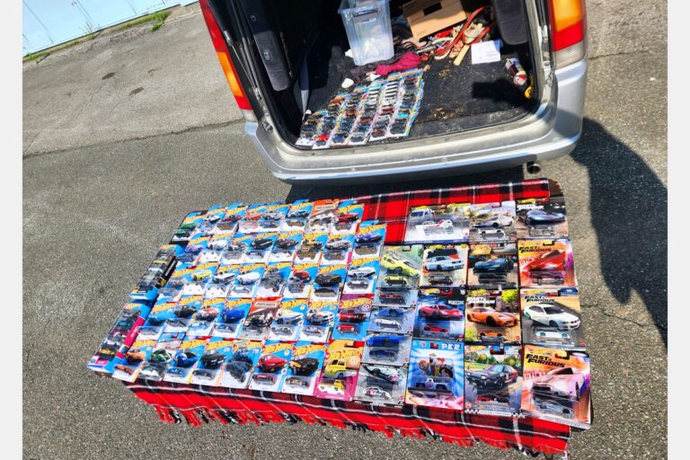 Hot Wheels and Matchbox diecast collection spread at a Cars and Coffee swap meet