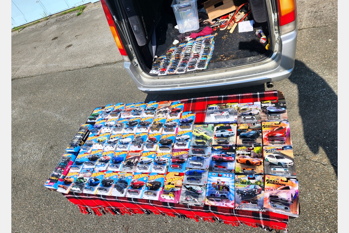 Hot Wheels and Matchbox diecast collection spread at a Cars and Coffee swap meet